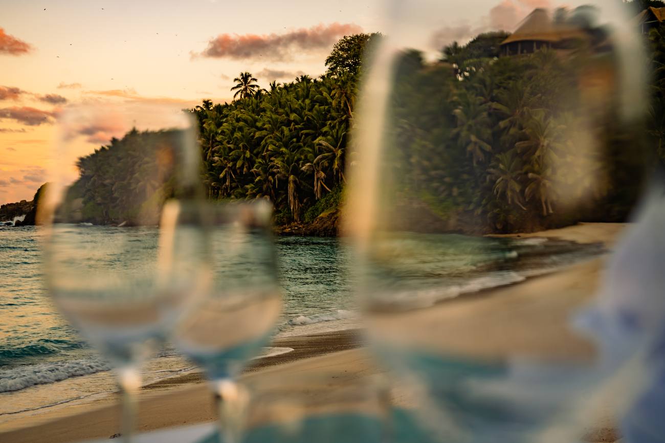 Wine glasses on the beach at sunset